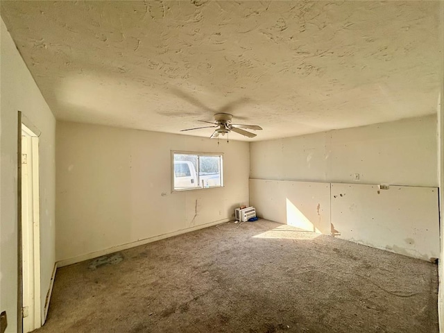 empty room with carpet floors, ceiling fan, and a textured ceiling