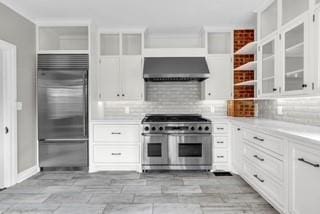 kitchen featuring open shelves, premium appliances, extractor fan, and tasteful backsplash