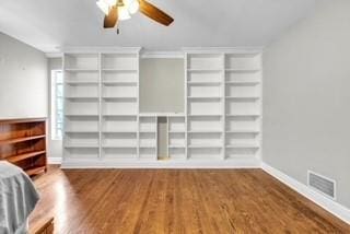 unfurnished bedroom featuring baseboards, visible vents, ceiling fan, and wood finished floors