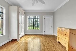 doorway to outside featuring a ceiling fan, crown molding, baseboards, and wood finished floors