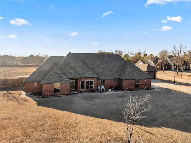 view of front of house featuring a shingled roof and brick siding