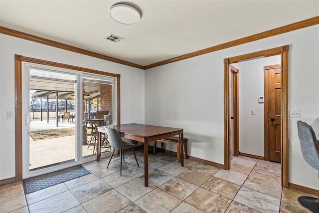 dining area featuring baseboards, visible vents, and crown molding