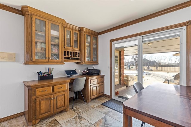 office area with crown molding, built in study area, and baseboards