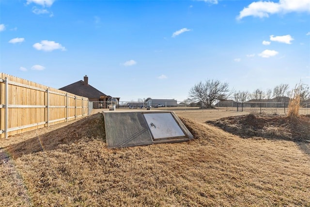 view of storm shelter with a fenced backyard