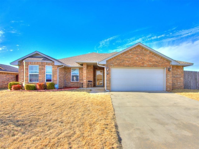 ranch-style house with concrete driveway, brick siding, a front lawn, and fence