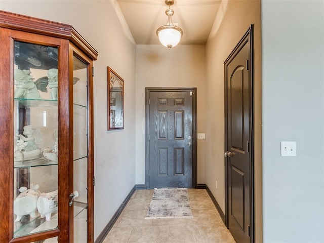 foyer featuring baseboards and light tile patterned flooring