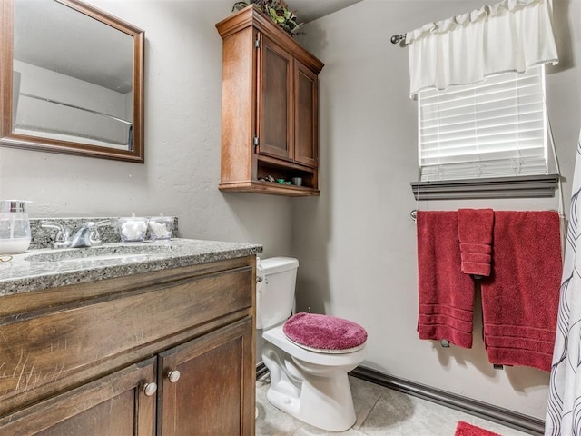 bathroom with tile patterned flooring, vanity, and toilet