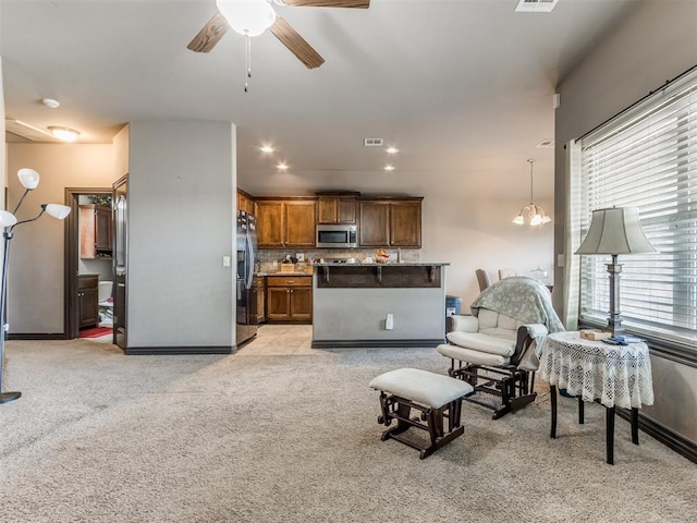 living room featuring light carpet, recessed lighting, visible vents, and ceiling fan with notable chandelier