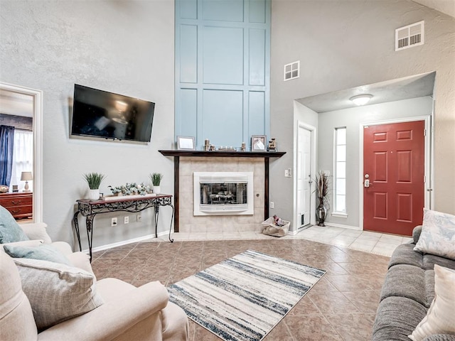 living area with plenty of natural light, a tile fireplace, and visible vents