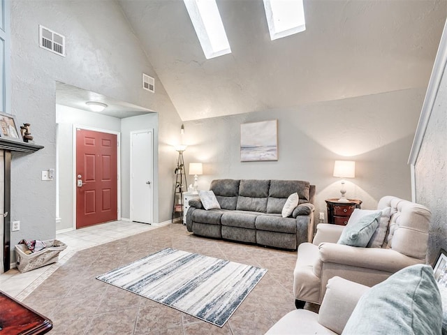 living area with high vaulted ceiling, a skylight, visible vents, and light tile patterned floors