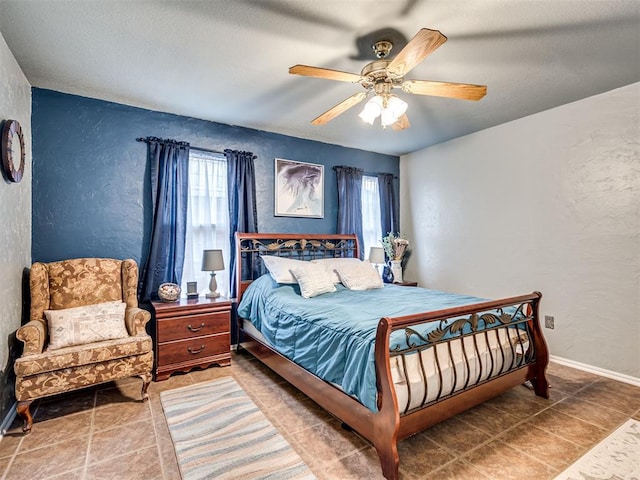 bedroom with ceiling fan, baseboards, and a textured wall