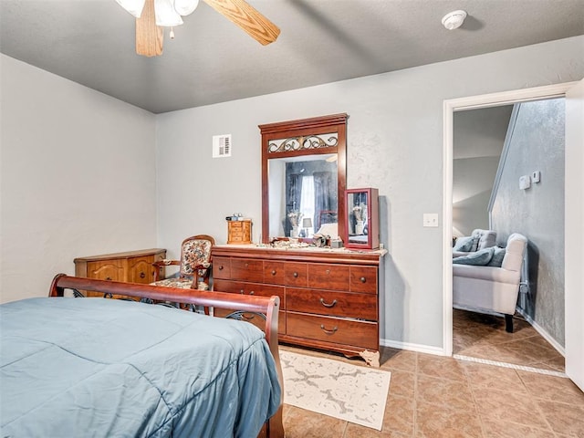 bedroom featuring ceiling fan, light tile patterned floors, visible vents, and baseboards