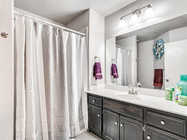 bathroom with a textured ceiling and vanity