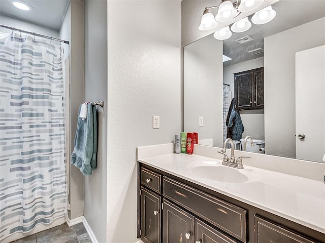 bathroom with a shower with shower curtain, baseboards, visible vents, and vanity