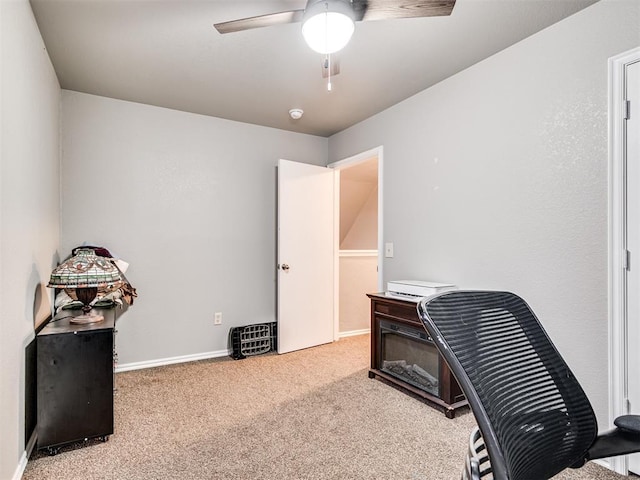 carpeted office featuring a ceiling fan and baseboards