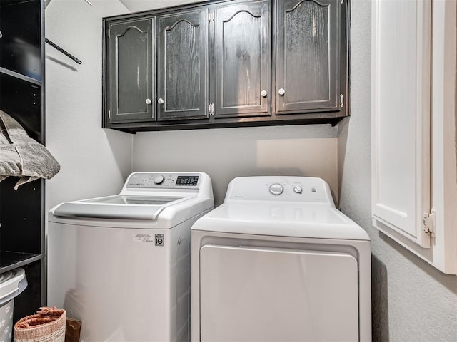 washroom featuring washer and clothes dryer and cabinet space