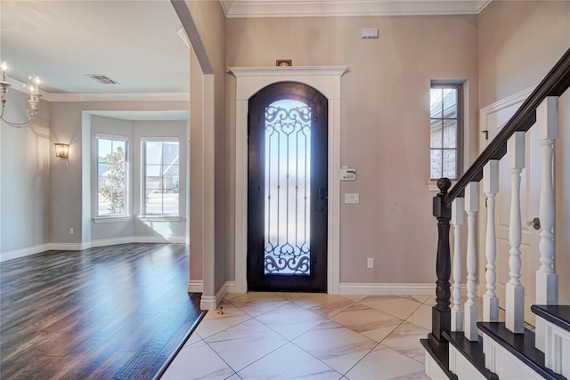 foyer with baseboards, stairway, plenty of natural light, and crown molding