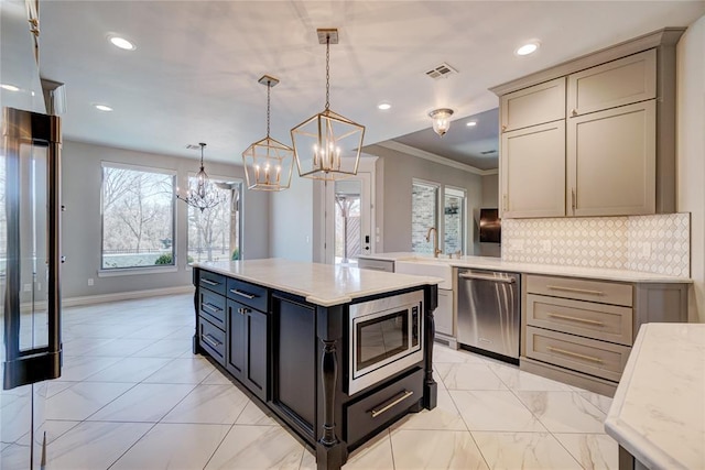 kitchen featuring pendant lighting, tasteful backsplash, visible vents, appliances with stainless steel finishes, and a kitchen island