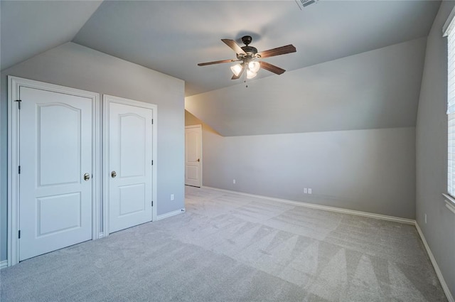 additional living space with lofted ceiling, light colored carpet, ceiling fan, and baseboards