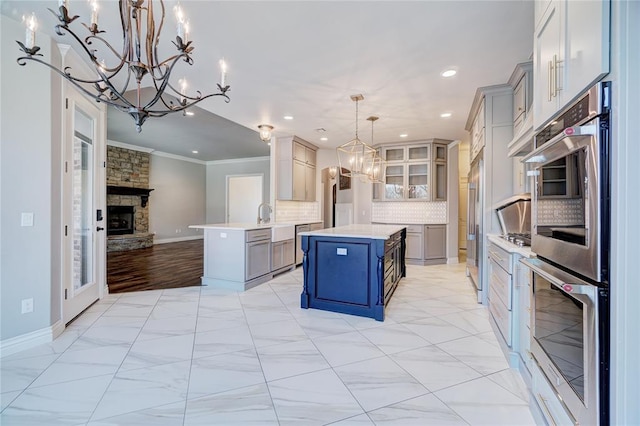 kitchen featuring light countertops, hanging light fixtures, glass insert cabinets, open floor plan, and a kitchen island