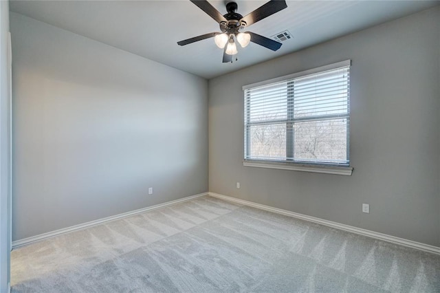 unfurnished room with baseboards, ceiling fan, visible vents, and light colored carpet