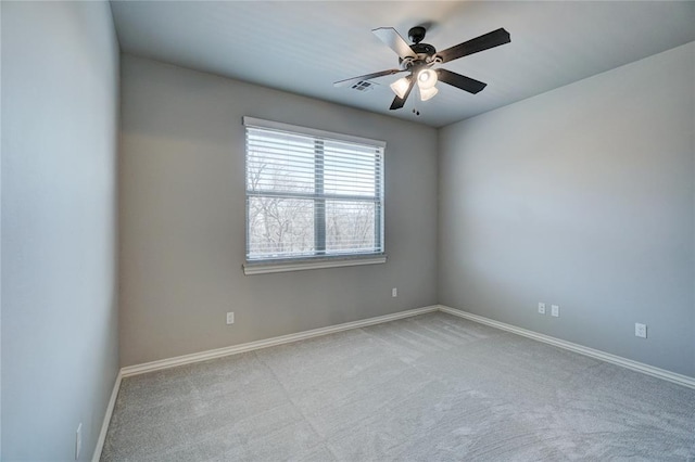 spare room with baseboards, ceiling fan, visible vents, and light colored carpet