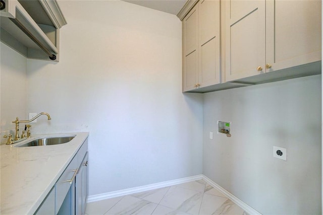 washroom featuring cabinet space, baseboards, electric dryer hookup, and a sink