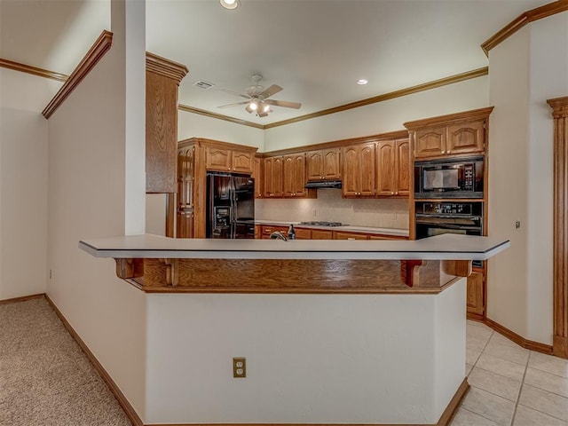 16632 Parkhurst Rd, Edmond, OK 73012 - kitchen with black appliances, a ceiling fan, a breakfast bar area, under cabinet range hood, and ornamental molding