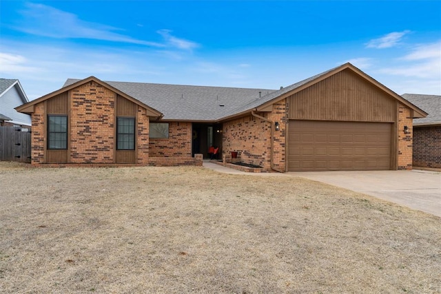 view of front of home featuring driveway, roof with shingles, a garage, and brick siding