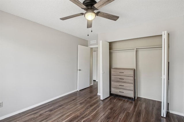 unfurnished bedroom featuring a closet, dark wood-style flooring, ceiling fan, and baseboards