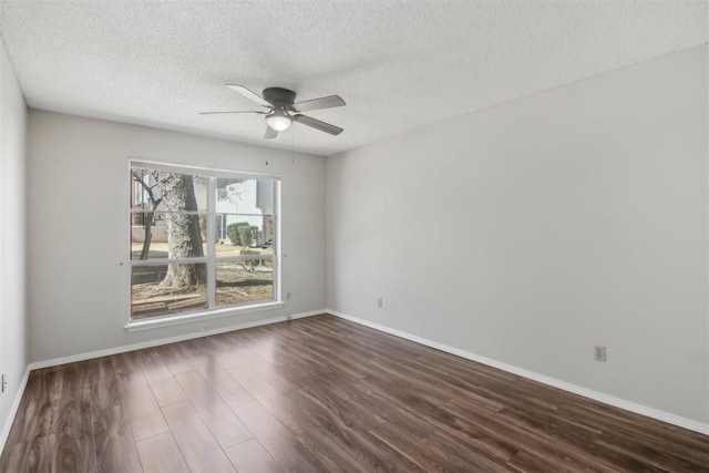 spare room featuring dark wood-style flooring, ceiling fan, a textured ceiling, and baseboards