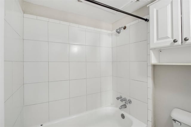 bathroom featuring tub / shower combination and toilet