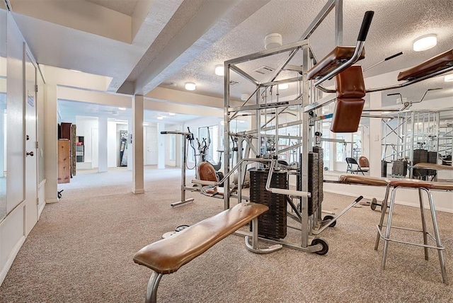 workout area featuring carpet and a textured ceiling