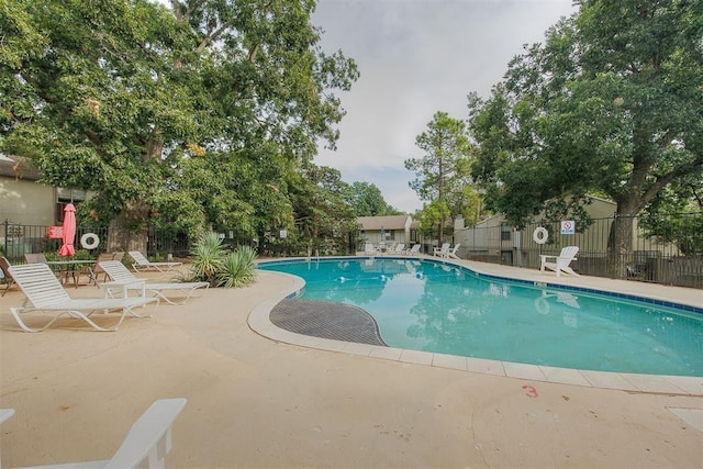 pool with fence and a patio