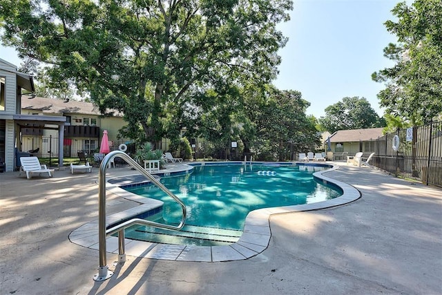 community pool featuring a patio area and fence