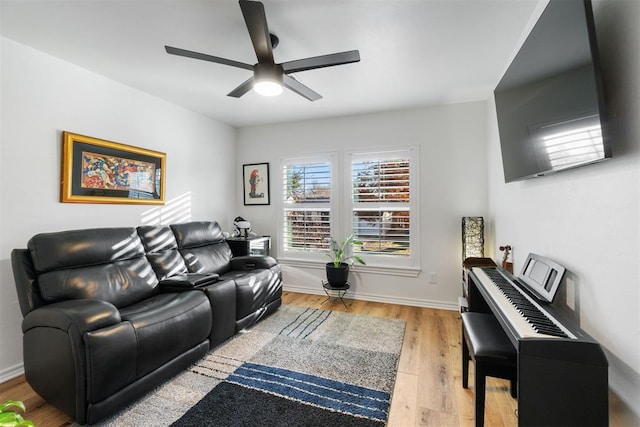 living area with light wood finished floors, baseboards, and a ceiling fan