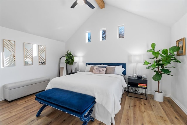 bedroom with lofted ceiling with beams, light wood-style flooring, baseboards, and ceiling fan