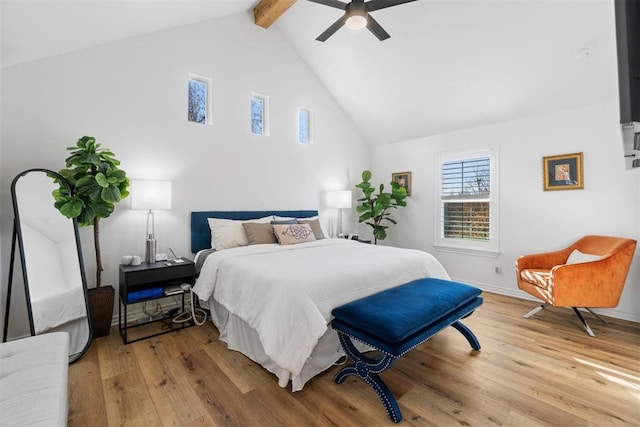 bedroom featuring baseboards, a ceiling fan, light wood-style flooring, high vaulted ceiling, and beam ceiling