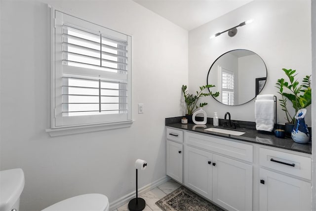 bathroom featuring marble finish floor, vanity, toilet, and baseboards