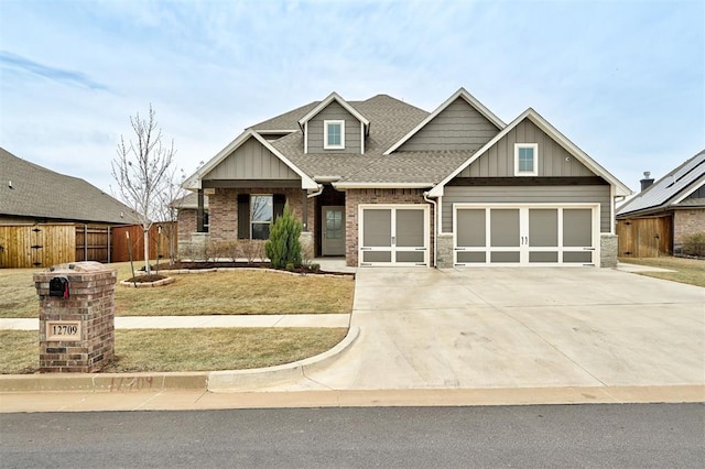 craftsman house featuring driveway, roof with shingles, fence, a front lawn, and board and batten siding