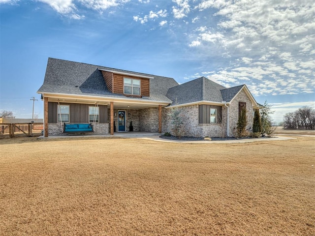 view of front of house featuring a front yard, fence, and roof with shingles