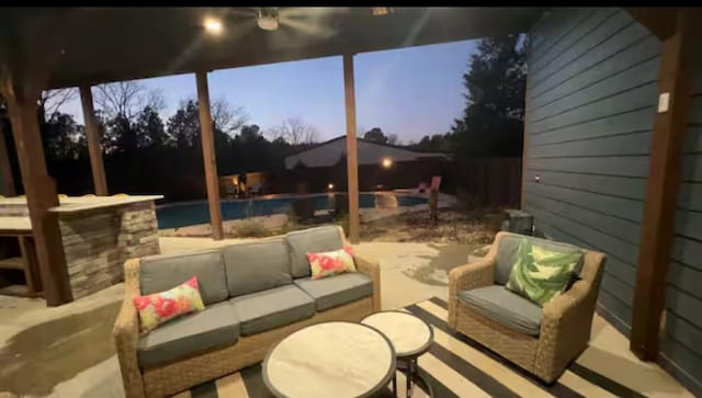 patio terrace at dusk featuring outdoor lounge area and an outdoor pool