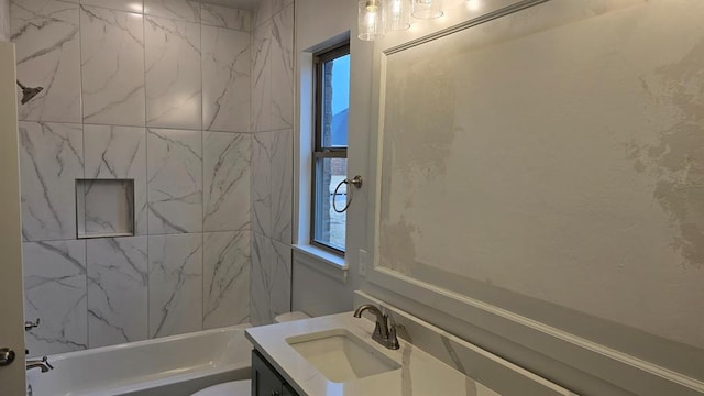 bathroom featuring washtub / shower combination, vanity, and toilet