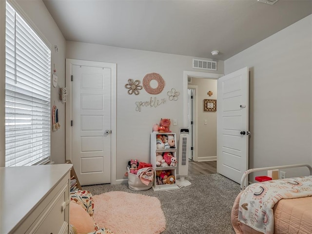 bedroom featuring light colored carpet, visible vents, baseboards, and multiple windows