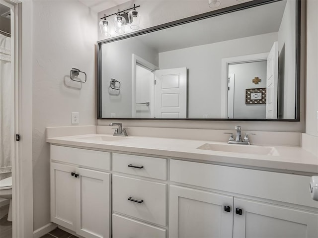 bathroom featuring a sink, toilet, and double vanity