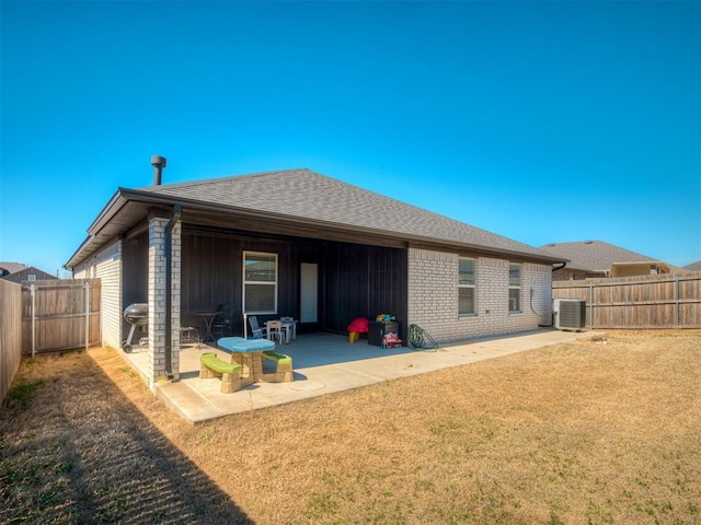 back of property featuring brick siding, a fenced backyard, central AC, and a patio