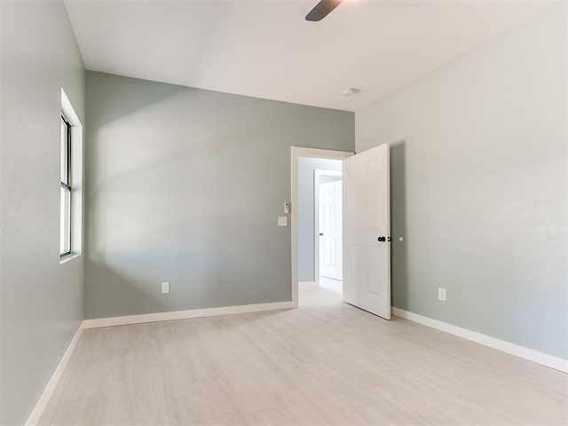 unfurnished room with a ceiling fan, light wood-style flooring, and baseboards