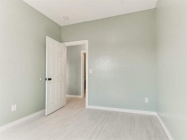 spare room featuring light wood-style flooring and baseboards