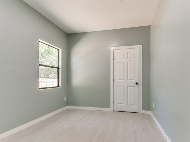 empty room with light wood-style flooring and baseboards