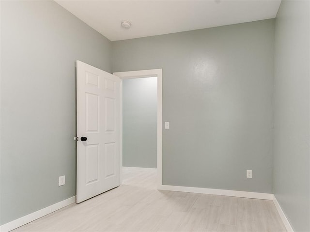 spare room with wood finished floors and baseboards